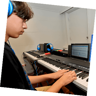 A focused teen student plays on a keyboard, enjoying their piano lessons in Pasadena.