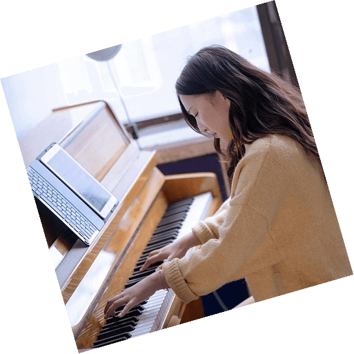 A woman with a focused expression plays chords on a keyboard.