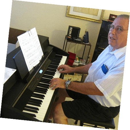 A focused senior plays a grand piano in a well-lit Pasadena piano studio while looking at the viewer.