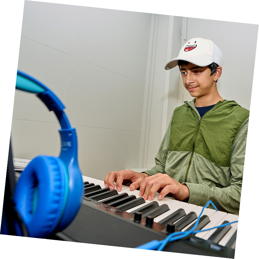Teen focused on the piano keys during a piano lesson.